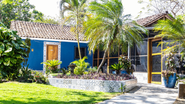 Beachfront view of Xalli Ometepe Beach Hotel with garden, lake, and volcanoes in background